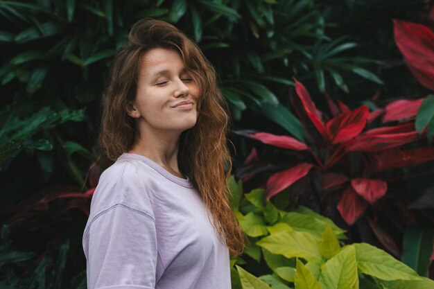 Retrato de una joven sobre un fondo natural verde mujer ecológica en un parque tropical o selva