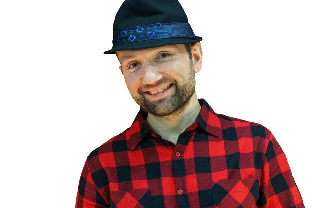 Foto retrato de un joven con un sombrero y una camisa a cuadros roja sobre un fondo blanco un hombre barbudo con una sonrisa en la cara