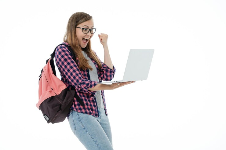 Foto retrato de una joven sonriente apuntado en la pantalla de una computadora portátil y una pc
