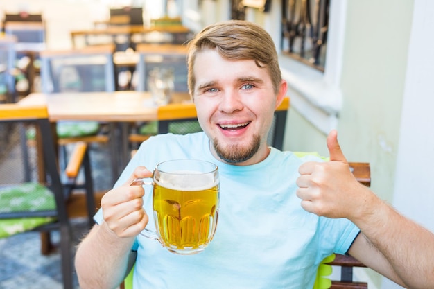 Foto retrato de un joven sonriente bebiendo un vaso