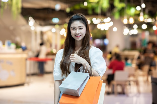Retrato de una joven sonriente con bolsas de compras