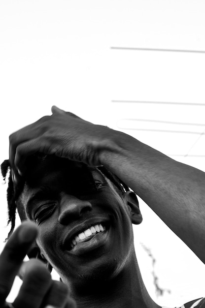 Foto retrato de un joven sonriente contra el cielo