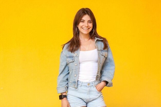 Foto retrato de una joven sonriente contra un fondo amarillo