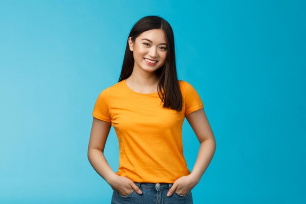 Foto retrato de una joven sonriente contra un fondo azul