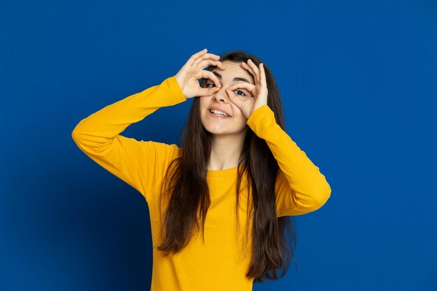 Foto retrato de una joven sonriente contra un fondo azul