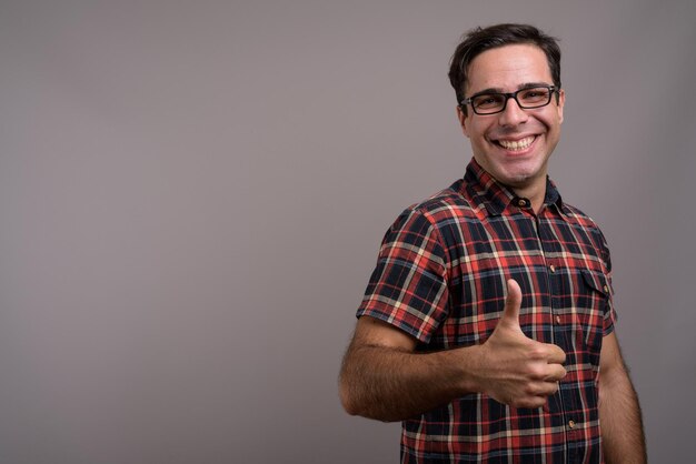 Foto retrato de un joven sonriente contra un fondo gris