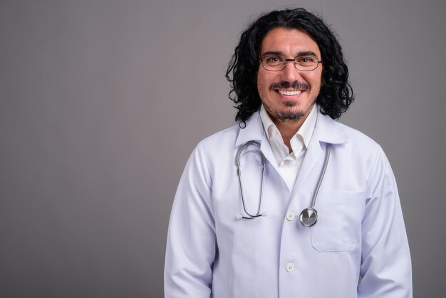 Retrato de un joven sonriente contra un fondo gris