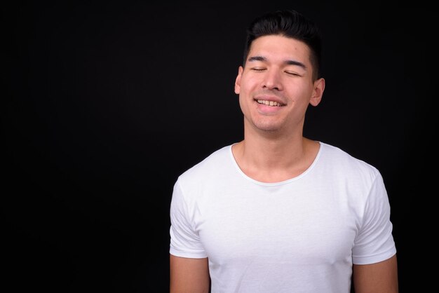 Foto retrato de un joven sonriente contra un fondo negro