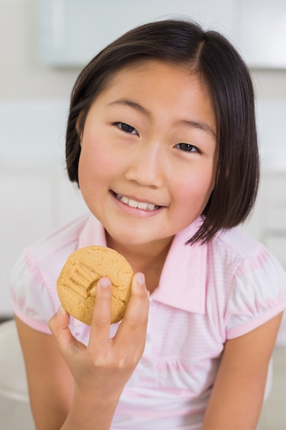 Retrato de una joven sonriente, disfrutando de galletas