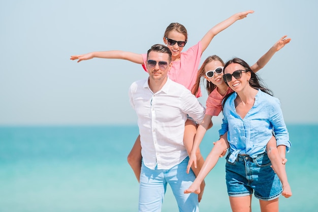 Retrato de una joven sonriente con gafas de sol contra el mar