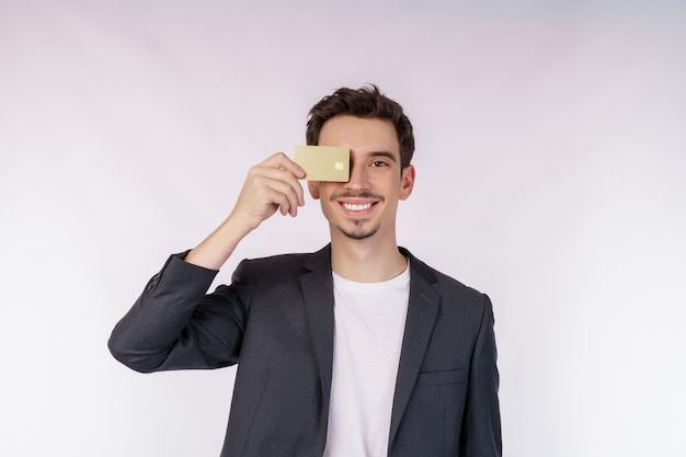 retrato, de, joven, sonriente, guapo, hombre de negocios, actuación, tarjeta de crédito, aislado, encima, fondo blanco