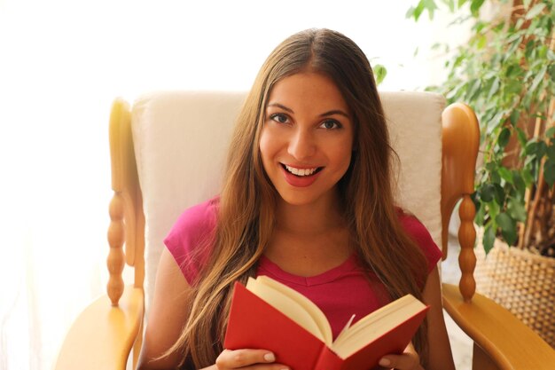 Foto retrato de una joven sonriente en un libro