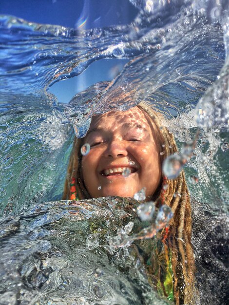 Foto retrato de una joven sonriente nadando en el agua