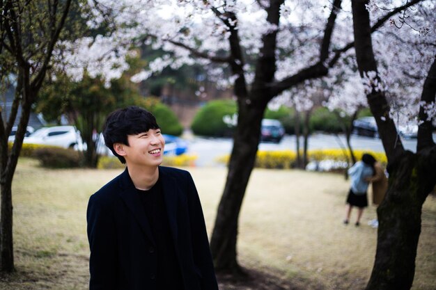 Retrato de un joven sonriente de pie al aire libre