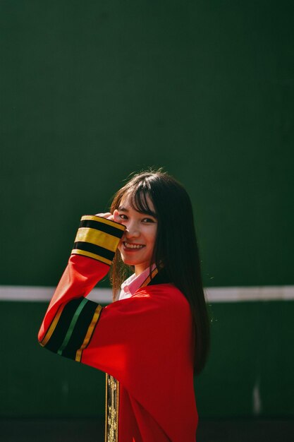 Foto retrato de una joven sonriente de pie al aire libre