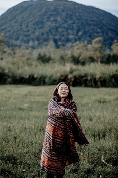 Retrato de una joven sonriente de pie en el campo