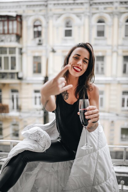 Foto retrato de una joven sonriente de pie contra un edificio en la ciudad