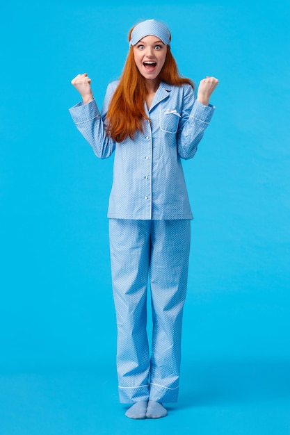 Retrato de una joven sonriente de pie contra un fondo azul