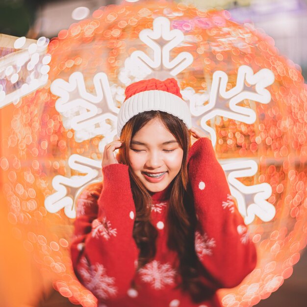 Retrato de una joven sonriente de pie contra la Navidad