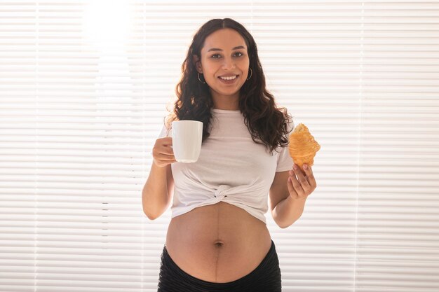 Foto retrato de una joven sonriente de pie contra una pared blanca