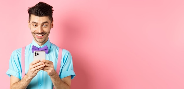 Foto retrato de un joven sonriente de pie contra la pared