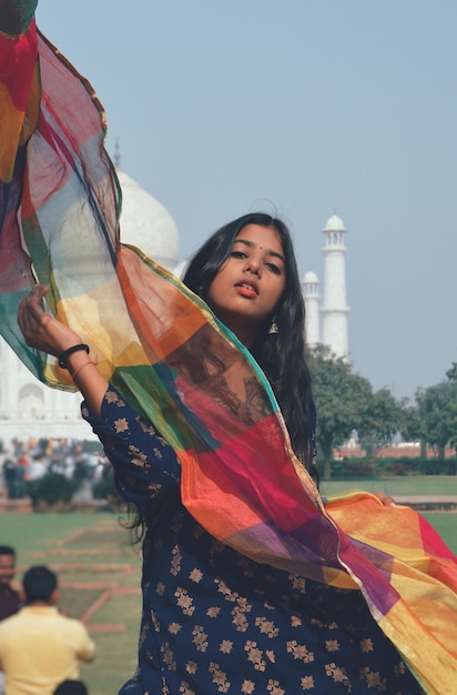 Retrato de una joven sonriente de pie frente al Taj Mahal