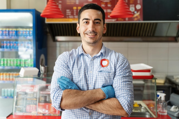 Foto retrato de un joven sonriente de pie en la tienda