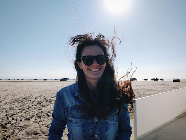 Retrato de una joven sonriente en la playa durante el día soleado