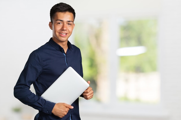 Retrato de joven sonriente con portátil