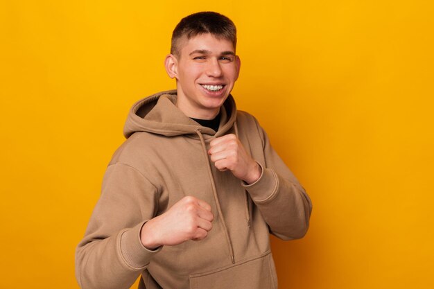 Foto retrato de un joven sonriente en posición de lucha tema deportivo