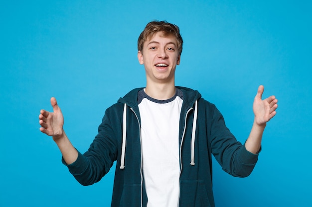 Retrato de joven sonriente en ropa casual gesticulando demostrando tamaño con espacio de trabajo horizontal aislado