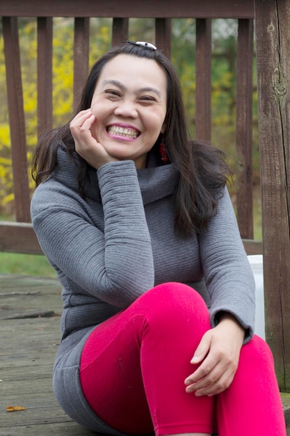 Foto retrato de una joven sonriente sentada al aire libre