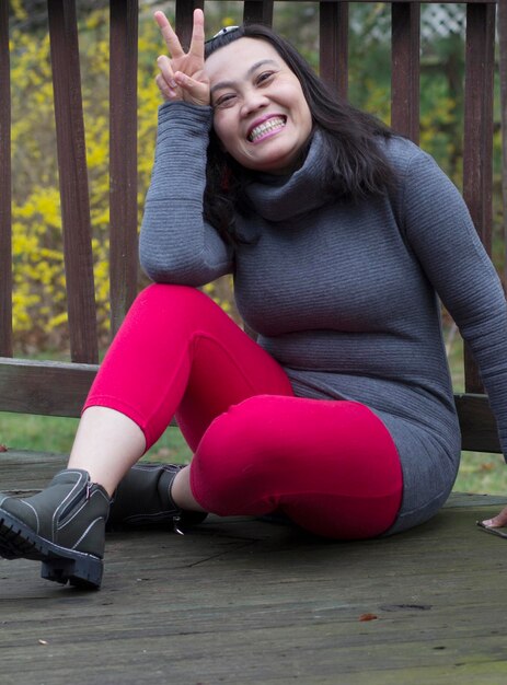 Foto retrato de una joven sonriente sentada al aire libre