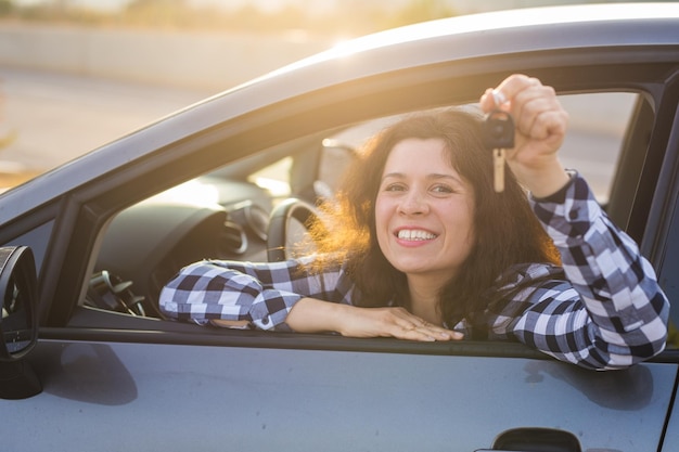 Foto retrato de una joven sonriente sentada en un coche
