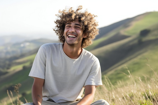 Retrato de un joven sonriente sentado en la cima de una colina cubierta de hierba