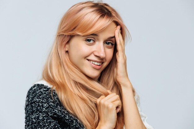 Foto retrato de una joven sonriente sobre un fondo blanco