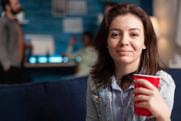 Foto retrato de una joven sonriente sosteniendo una bebida