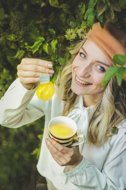 Foto retrato de una joven sonriente sosteniendo una bebida