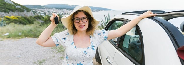 Foto retrato de una joven sonriente sosteniendo un coche
