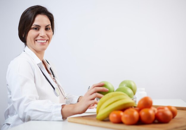 Foto retrato de una joven sonriente sosteniendo frutas