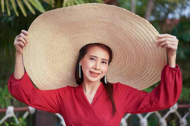 Retrato de una joven sonriente sosteniendo un sombrero