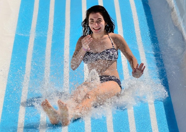 Retrato de una joven sonriente en un tobogán acuático