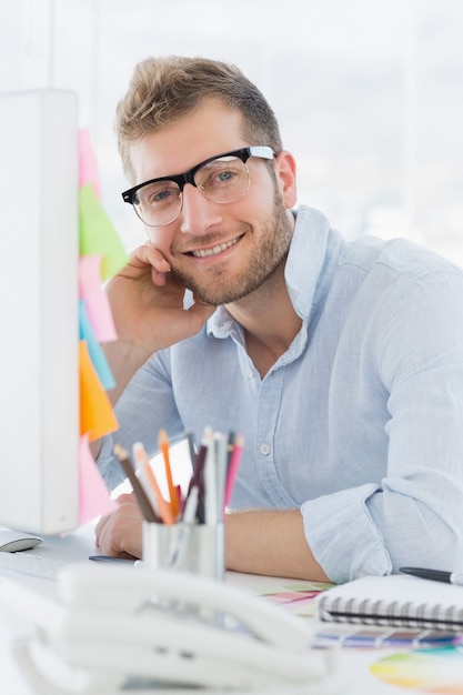 Retrato de un joven sonriente usando la computadora