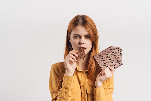 Retrato de una joven sonriente usando un teléfono móvil contra un fondo blanco