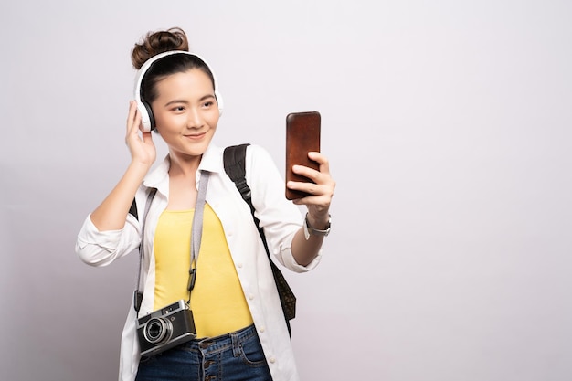 Retrato de una joven sonriente usando un teléfono móvil