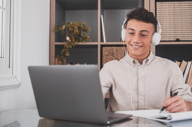 Retrato de un joven sonriente usando un teléfono móvil