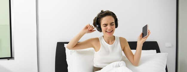 Foto retrato de una joven sonriente usando un teléfono móvil