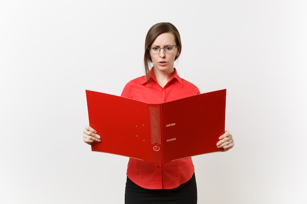 Retrato de joven sorprendido profesor de negocios triste mujer en camisa roja, gafas con carpeta con documentos de papeleo aislado sobre fondo blanco. Enseñanza de la educación en el concepto de la universidad de secundaria.