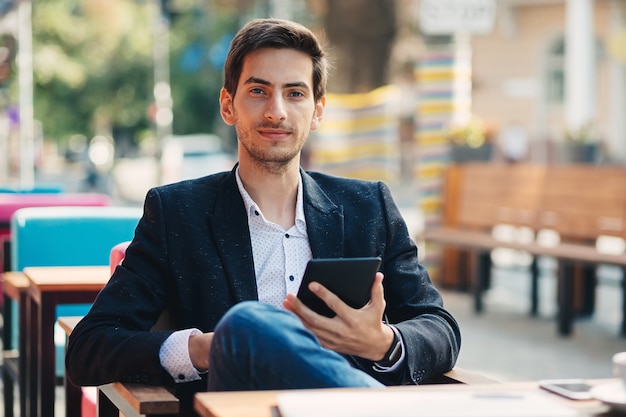 Foto retrato joven sosteniendo la tableta en la mano.