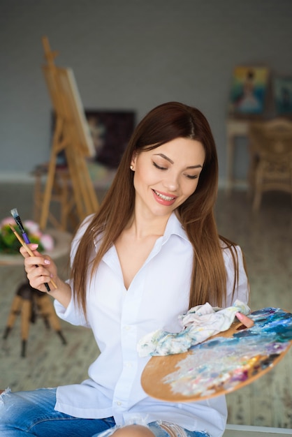 Retrato de joven talentoso cuadro de pintura en estudio de arte con inspiración